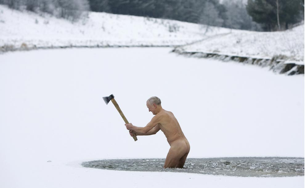 Naked old man chopping ice